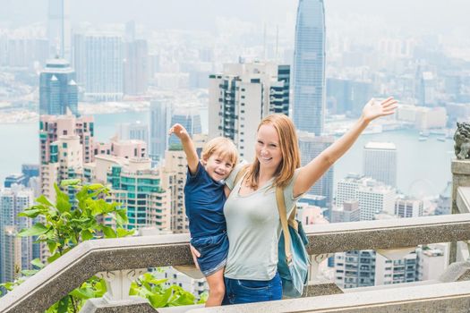 Mom and son travelers at the peak of Victoria against the backdrop of Hong Kong. Traveling with children concept