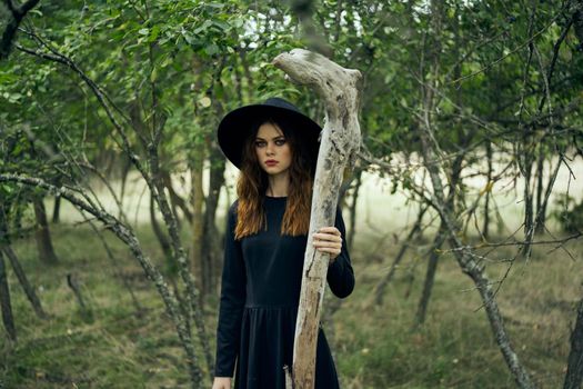 woman in witch costume in forest posing staff logic