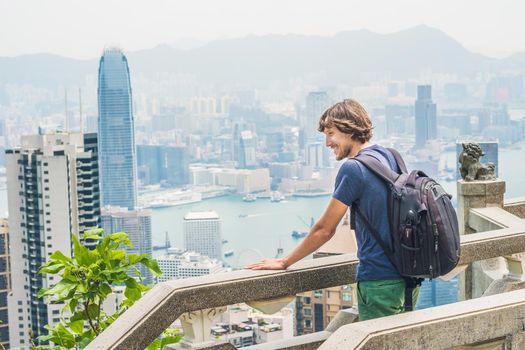 Young man traveler at the peak of Victoria against the backdrop of Hong Kong