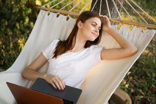 woman with laptop lies in hammock freelance travel
