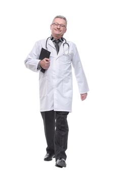Full length portrait of a smiling male doctor walking towards the camera isolated on white background