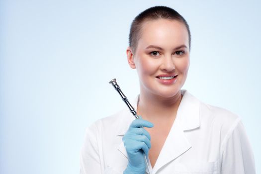 Portrait of a woman dermatologist holding cosmetic device attachment