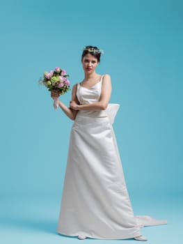 beautiful woman wearing wedding dress against cyan background