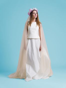 beautiful woman wearing wedding dress against cyan background
