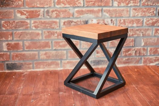 stylish stool against a red brick wall