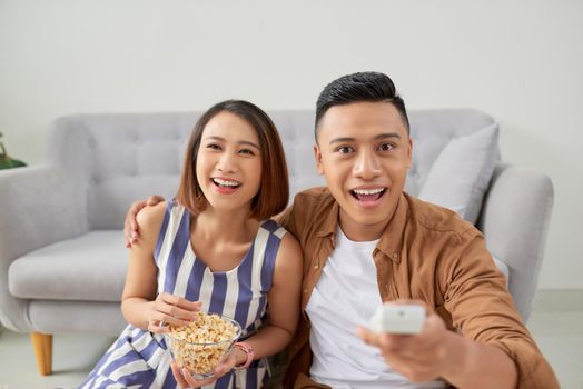 Couple using a remote control while sitting on floor