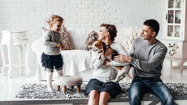 portrait of a happy family and their pet in a cozy living room