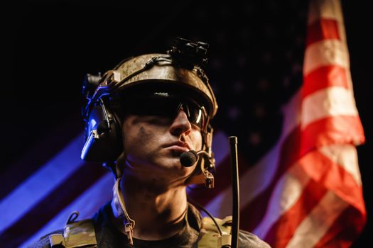 Portrait of special forces soldier in glasses and helmet against US national flag