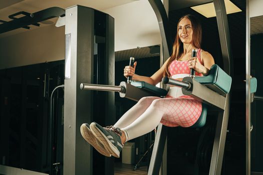 Woman bodybuilder training abs in a gym