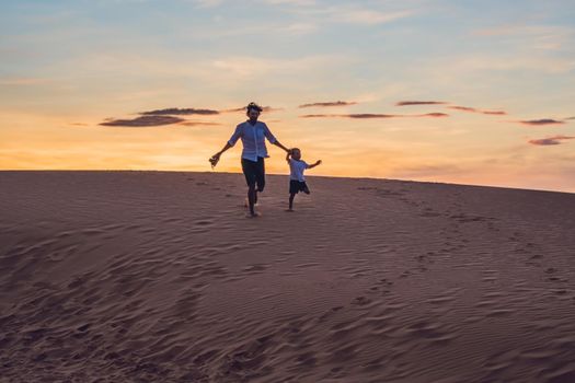 Father and son at the red desert at dawn. Traveling with children concept