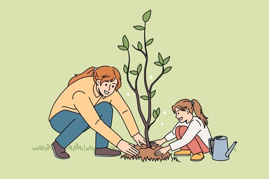 Happy mom and daughter plant tree together