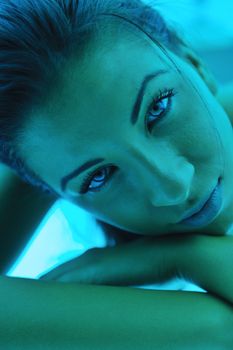 Beautiful young woman tanning in solarium