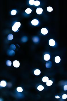 Christmas time and holiday mood concept. Blurred blue xmas tree lights as bokeh background
