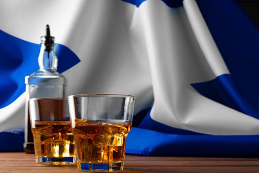Bottle of whisky against flag of Scotland