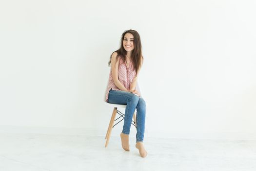 Young lady sitting on chair in white background with copy space