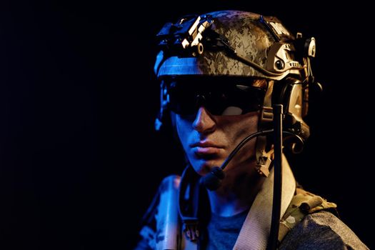 Portrait of special forces soldier in helmet and glasses in the dark