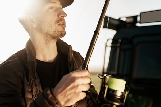 Portrait of a young male fisherman with fishing rod