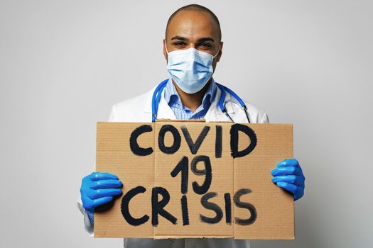 'Covid-19 crisis' placard in hands of protester man.