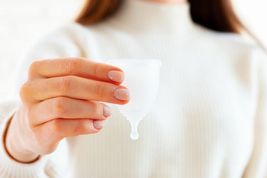 Menstrual cup in hands of a woman close up