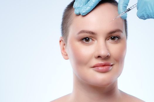 Beautiful woman with short hair gets a beauty injection in her face