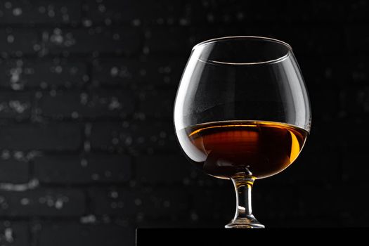 Whisky glass against dark black grunge wall
