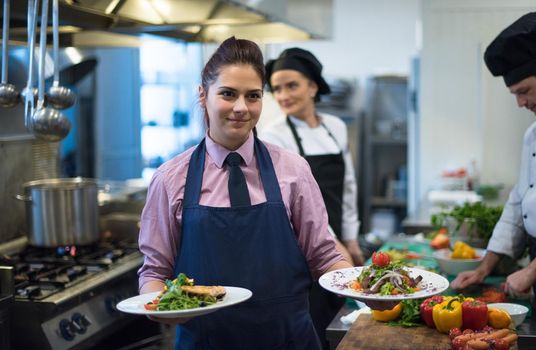 young waitress showing dishes of tasty meals