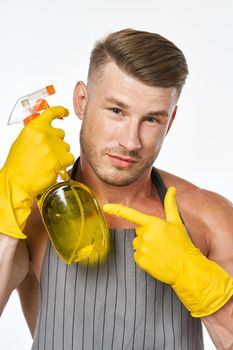cheerful man in apron detergent posing muscles