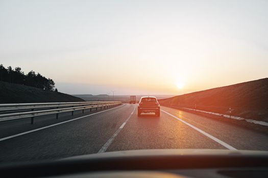 Passenger car driving on highway at dawn