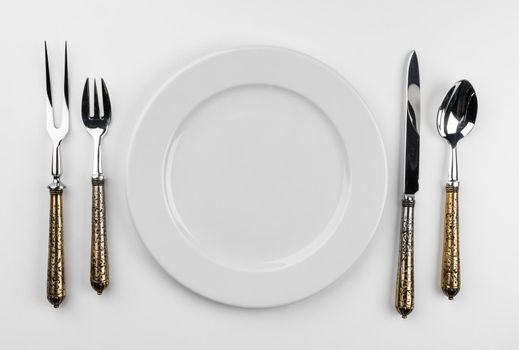 Empty plate with cutlery isolated on white background