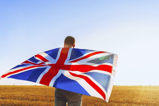Man with a flag of Great Britain standing in field