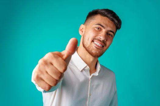 Positive handsome hispanic businessman showing thumb up gesture