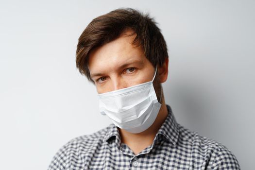 Man wearing hygienic mask against grey background