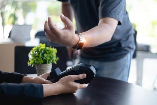 Modern man paying insurance or house bill by smartwatch. Accepting payment over nfc technology.