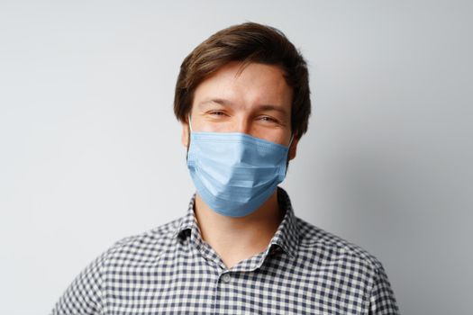 Man wearing hygienic mask against grey background