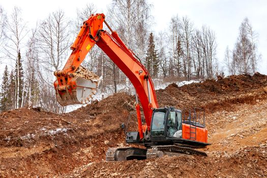 Modern excavator building a road in the forest