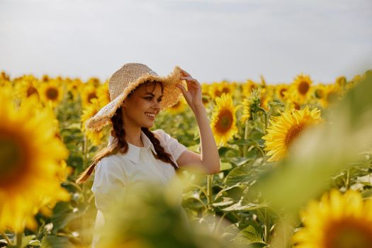 woman with pigtails in a hat on a field of sunflowers landscape. High quality photo