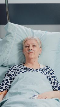 Elder patient with IV drip bag and nasal oxygen tube