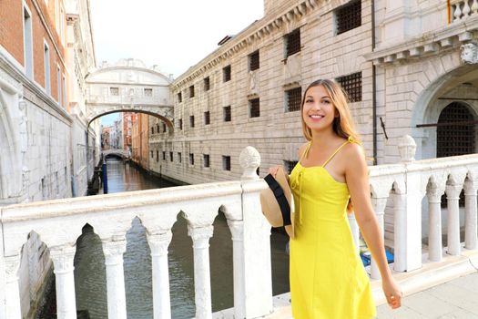 Happy young woman on Venice Bridge of Sighs. Beautiful girl looking to the side on Venice bridge, Italy.