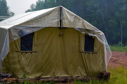 Military tent in the field. field camp in nature. large green tarpaulin tent. temporary field camp