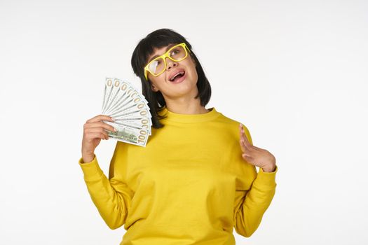 woman in a yellow sweater with money in her hands fun wealth