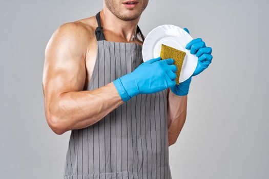 a man in an apron washes the dishes service housework