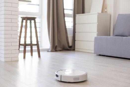 Smart House. Vacuum cleaner robot runs on wood floor in a living room
