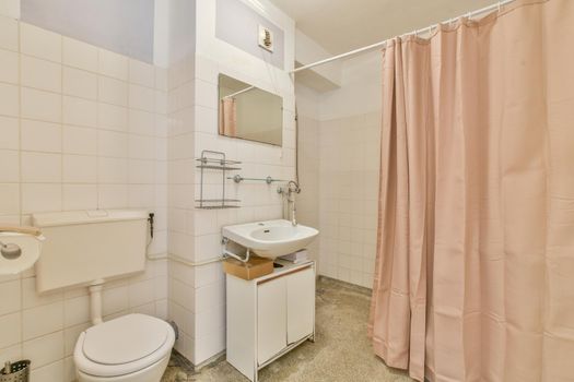 Bathroom with a pink curtain separating the shower