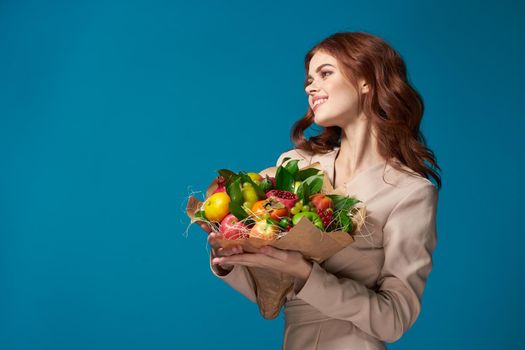 pretty woman beige coat fruit bouquet in hands isolated background