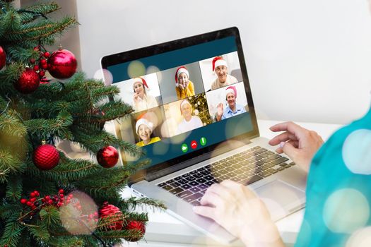 Christmas greetings online. a woman in a white sweater and red Santa hat uses a laptop to make video calls to friends, parents, and for online shopping