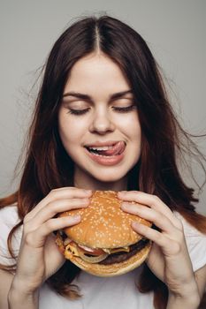 woman with a hamburger in her hands a snack fast food close-up