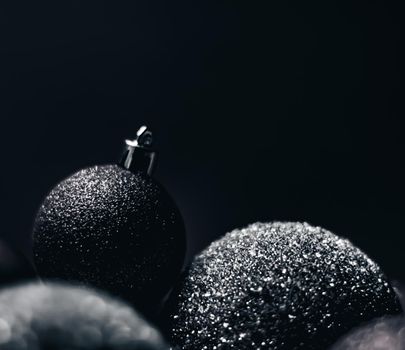 Christmas holiday and festive decoration concept. Black baubles as minimalistic xmas background