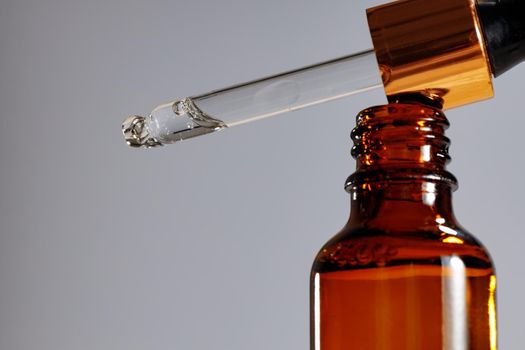 Skincare serum in glass dropper bottle close up