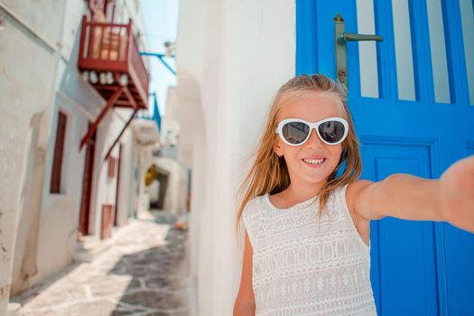 Adorable little girl at old street of typical greek traditional village