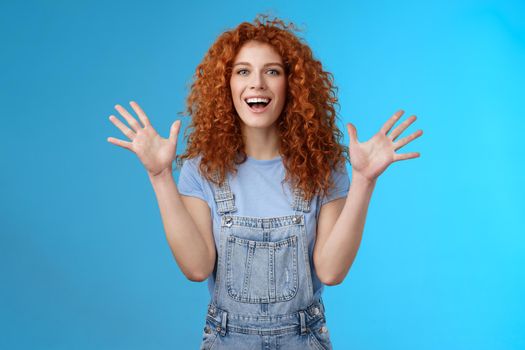 Charismatic bright happy amused redhead good-looking summer ginger girl raise hands delighted cheering flattered smiling broadly white toothy grin express happiness joy studio background